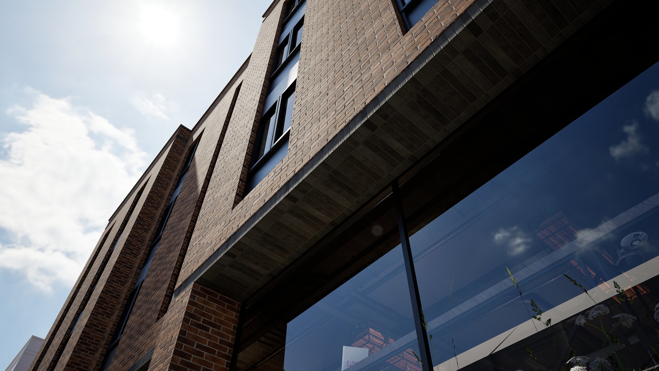 Modern mixed-use brick building with layered facade, large storefront windows, and vertical brick columns against blue sky
