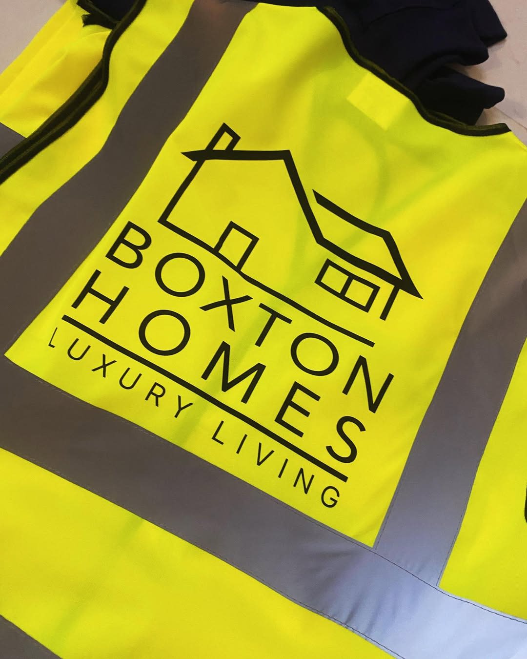 High-visibility safety vest printed with the Boxton Homes house logo and 'Luxury Living' tagline
