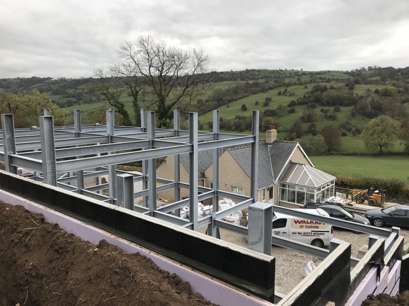 Modernist house under construction with steel frame and insulation