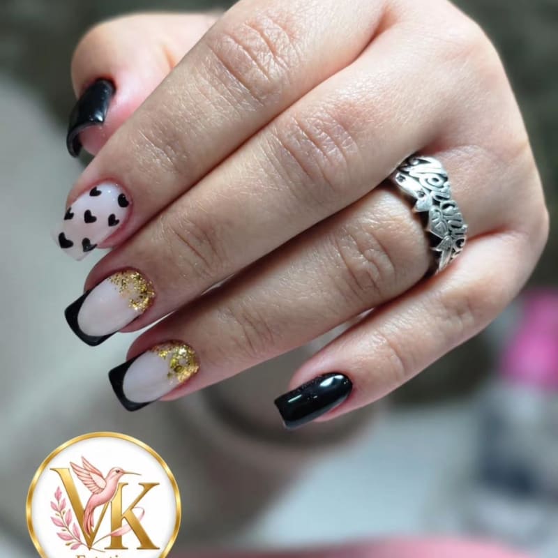 Uñas con francesa negra, corazones pintados a mano y foil dorado