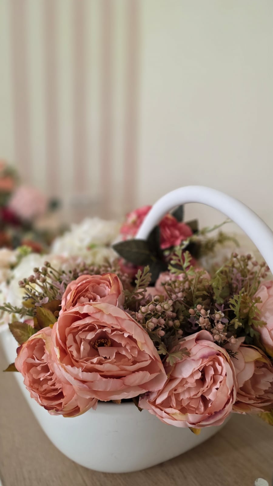 Cesta blanca con peonías rosas en el salón