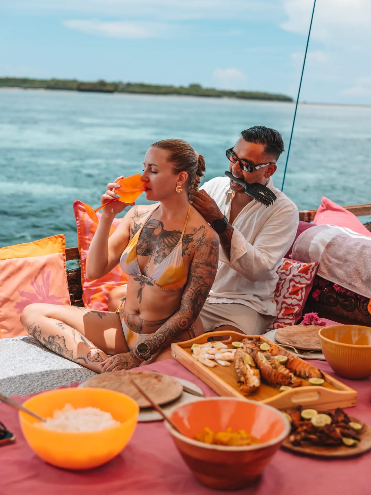 Couple walking along a white sand beach in Zanzibar at low tide, Indian Ocean honeymoon Tanzania