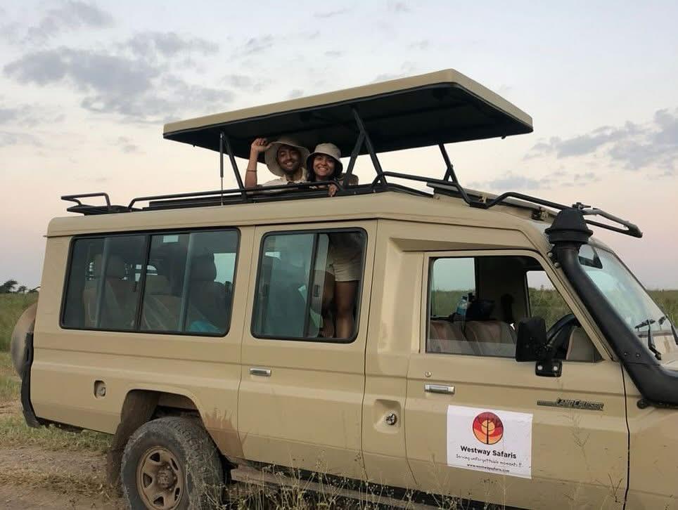 Couple watching wildlife from a private Westway Safaris Land Cruiser on a Serengeti game drive, Tanzania