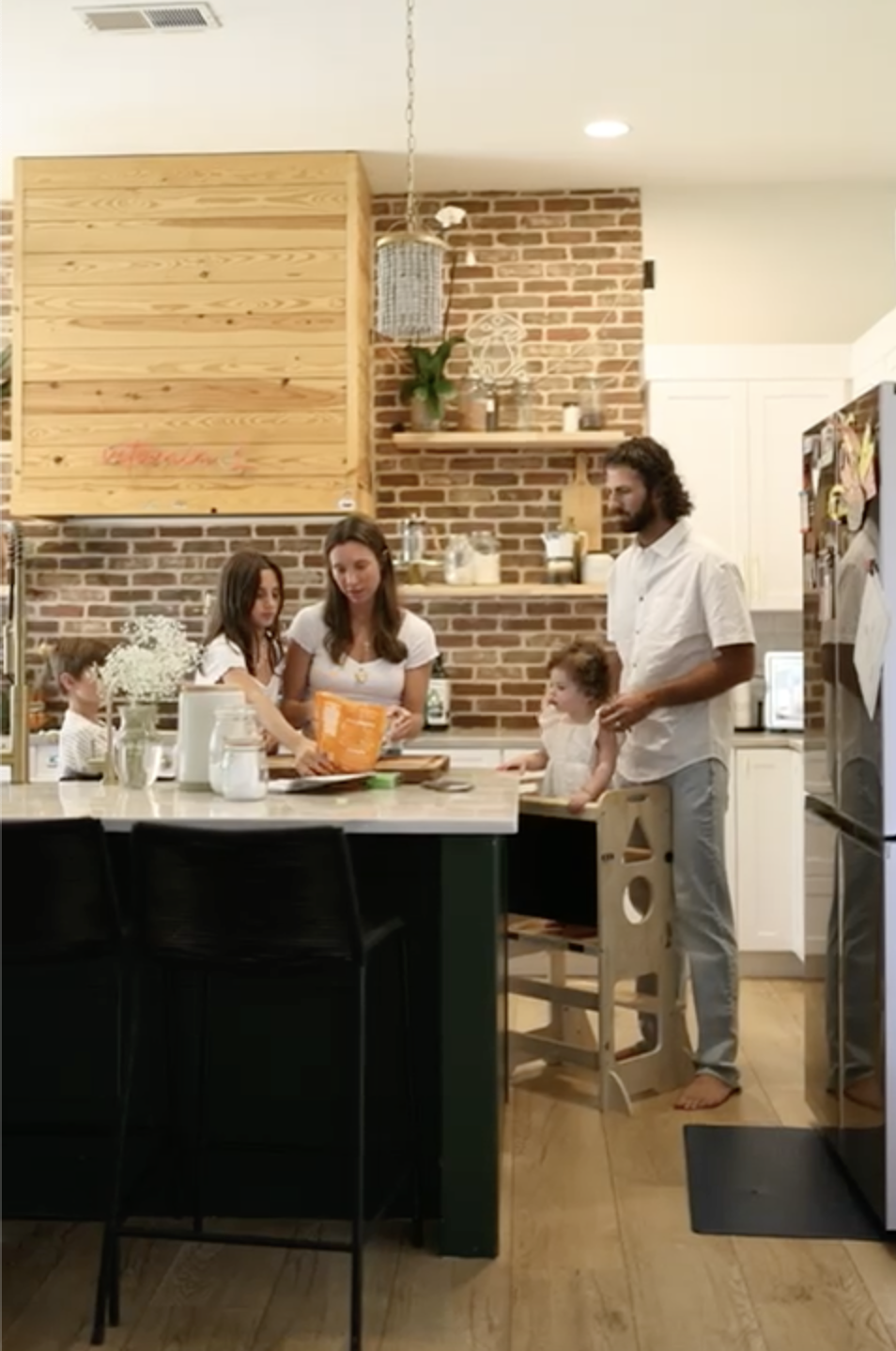 Family gathered around a table at home, representing the routines and rhythms that support motherhood and family life.
