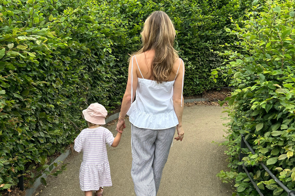 Woman walking outdoors with a child as part of a simple morning movement routine.