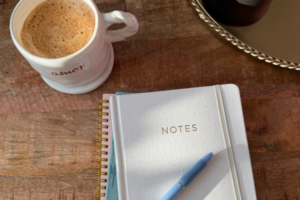 Coffee and notebook on a table representing a quiet and intentional start to the morning.