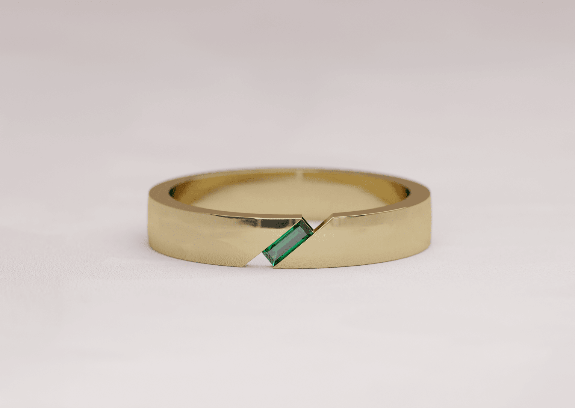 Mens wedding band featuring a portrait cut asymmetric emerald in 18k yellow gold