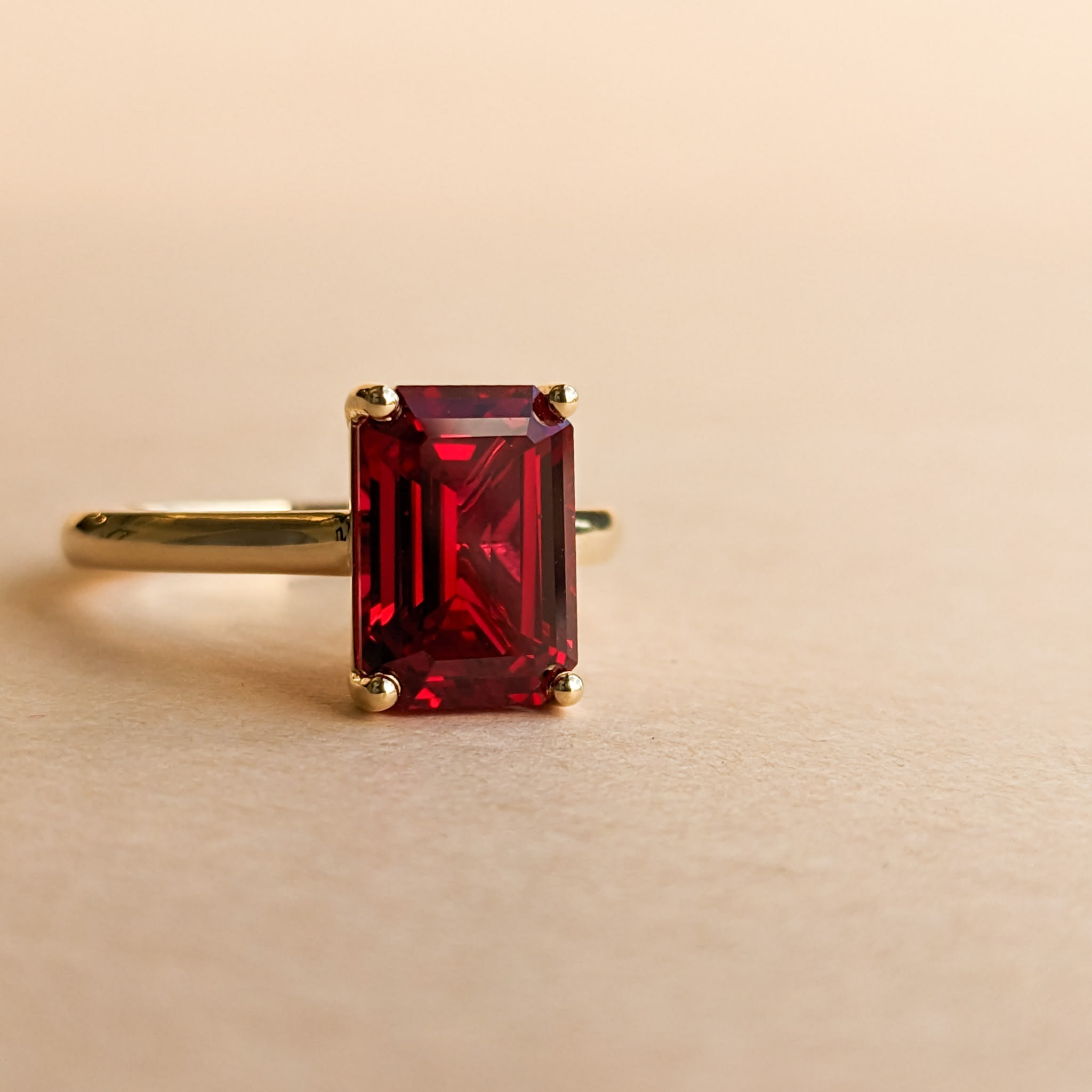 Emerald cut ruby engagement ring in a yellow gold band