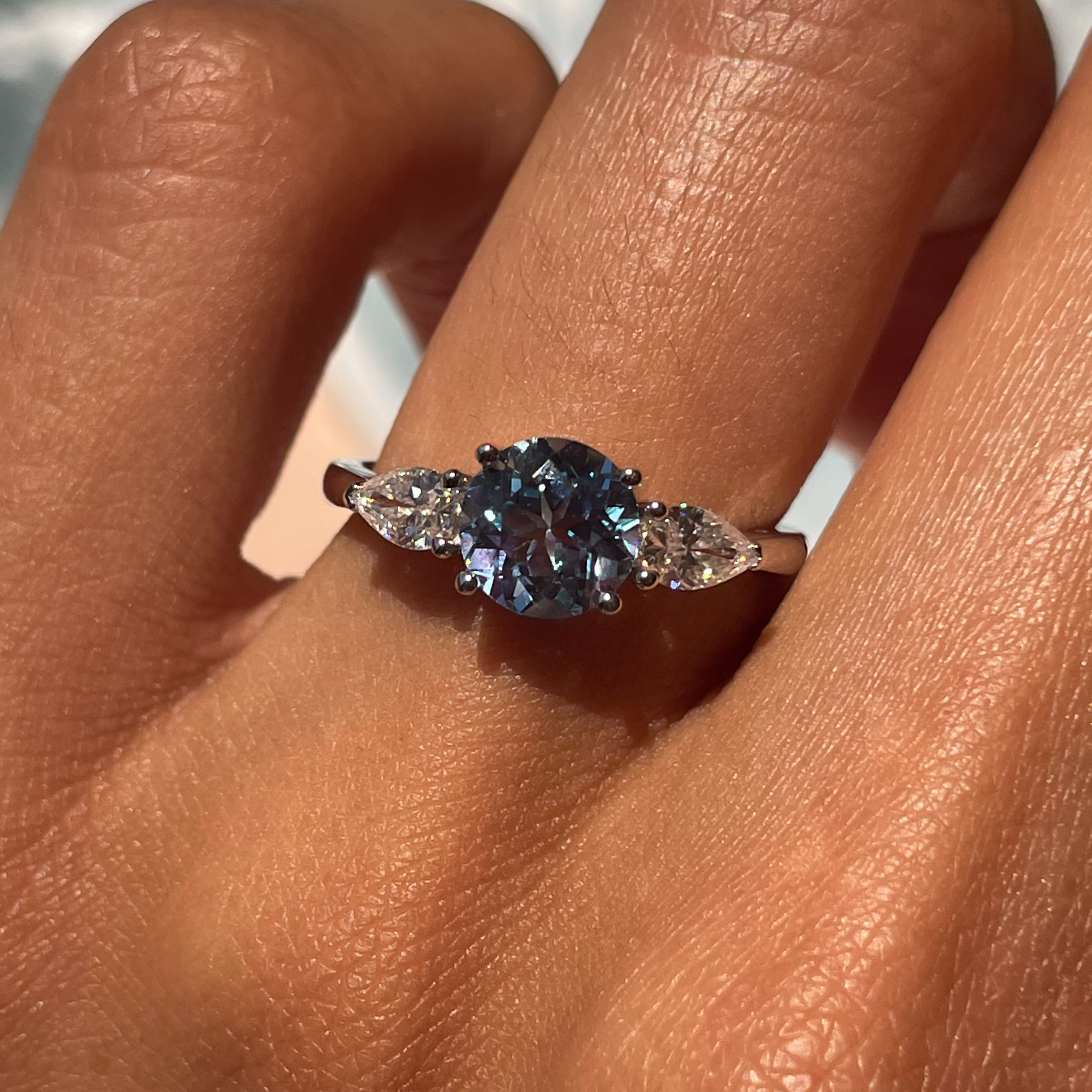 1 carat equivalent blue sapphire with two accenting pear diamond stones