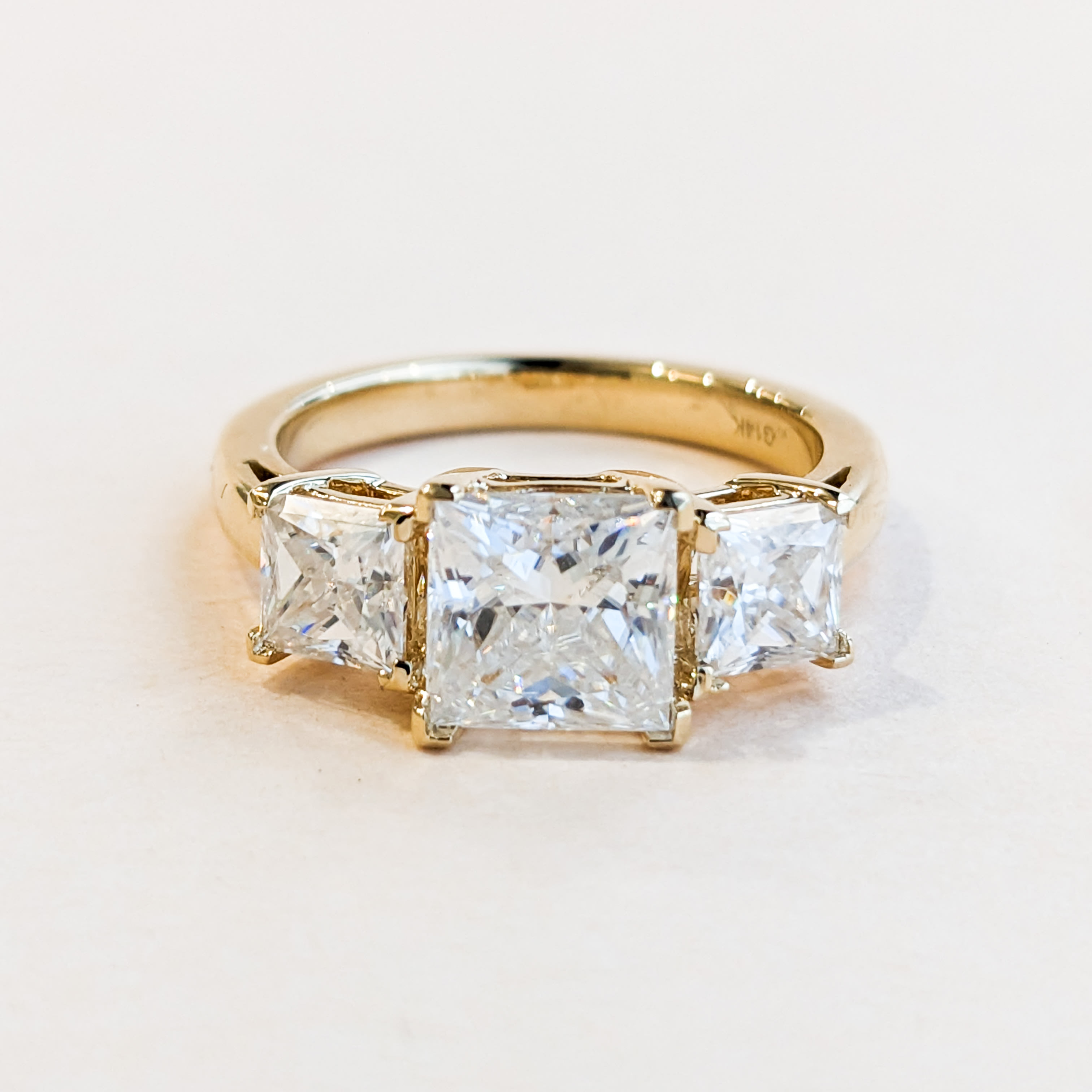 Three stone princess cut diamond in 14 karat yellow gold 