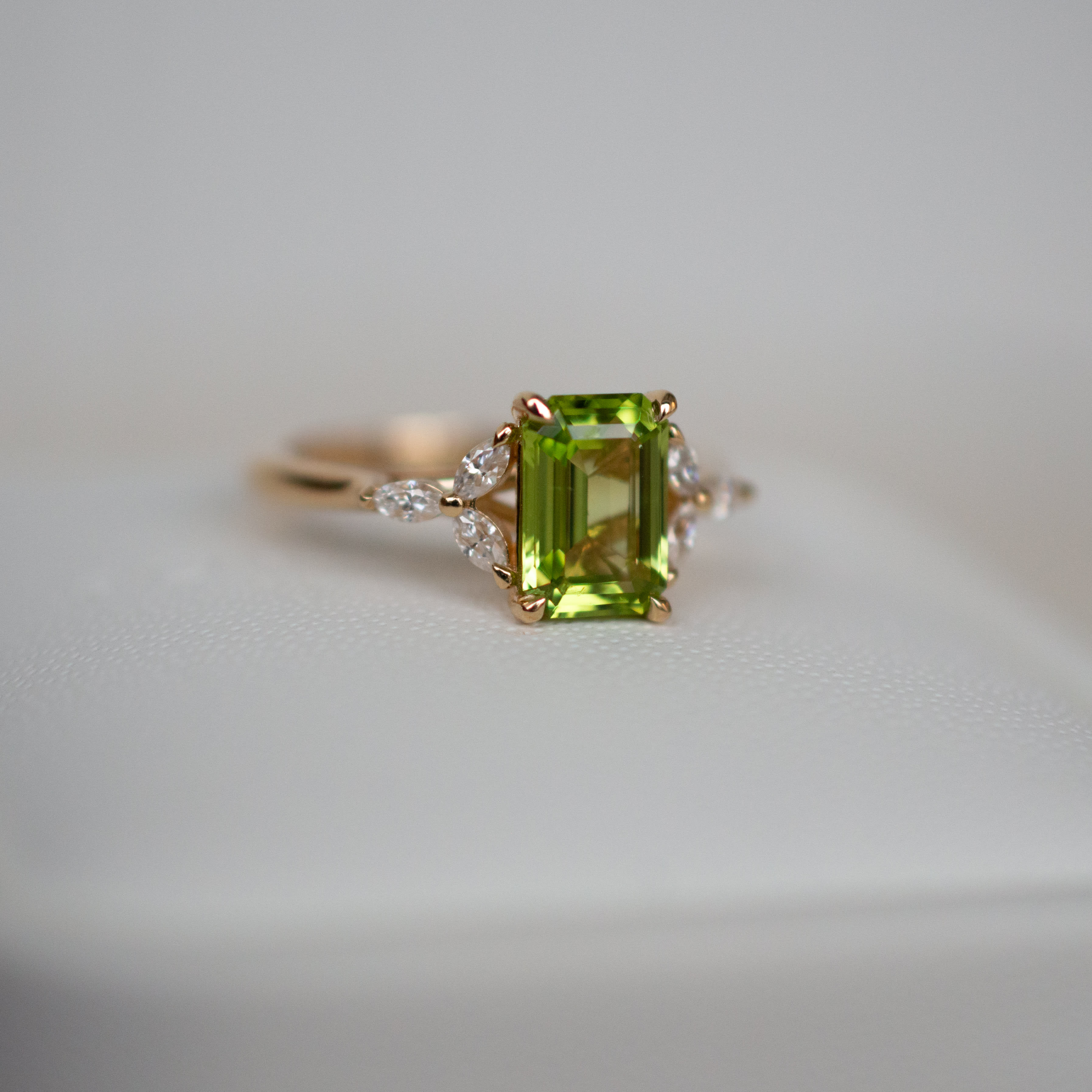 Emerald cut sapphire featuring marquise moissanites on a yellow gold band