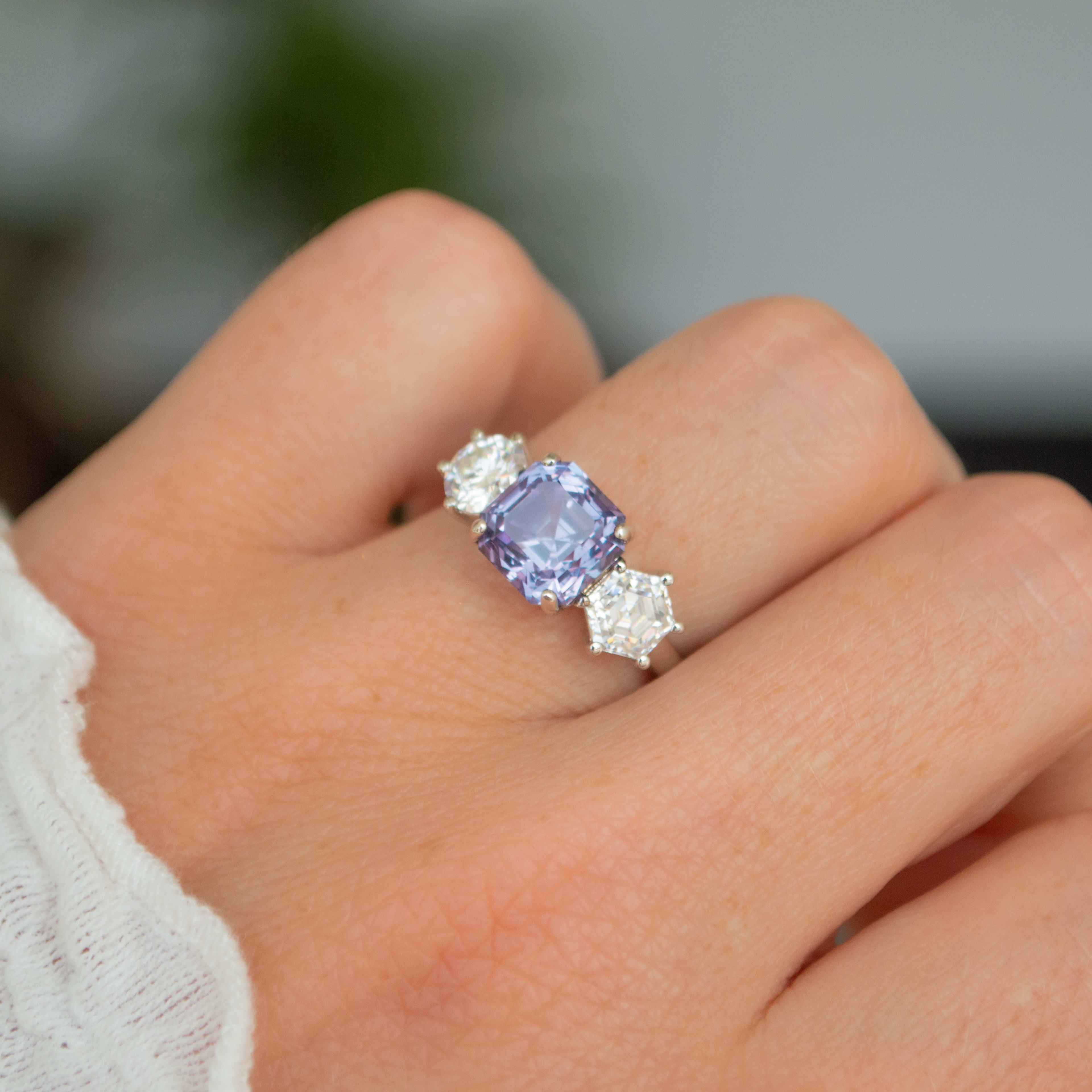 3 stone engagement ring featuring an Asscher cut sapphire in yellow gold