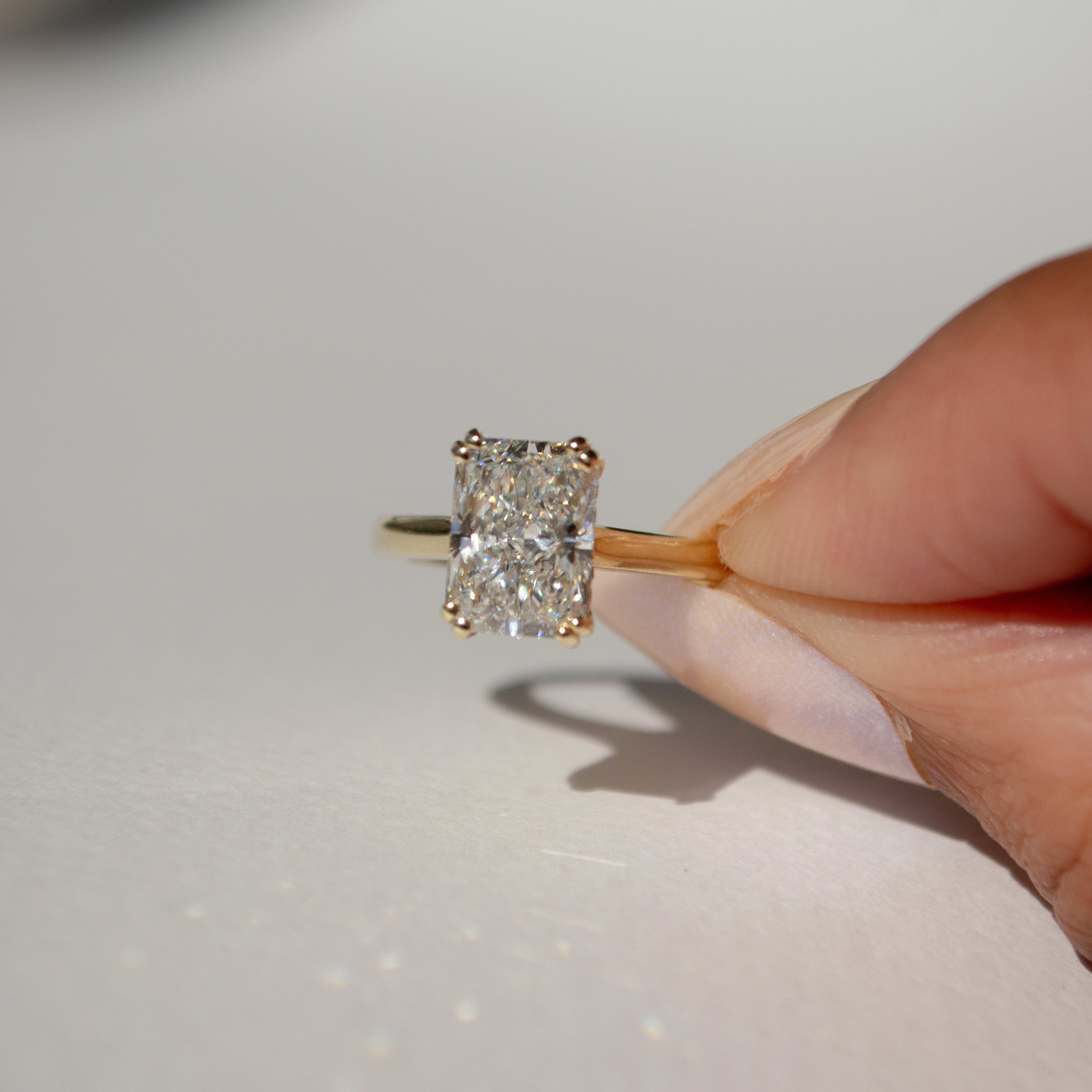 Radiant cut diamond with double prongs in a yellow gold band