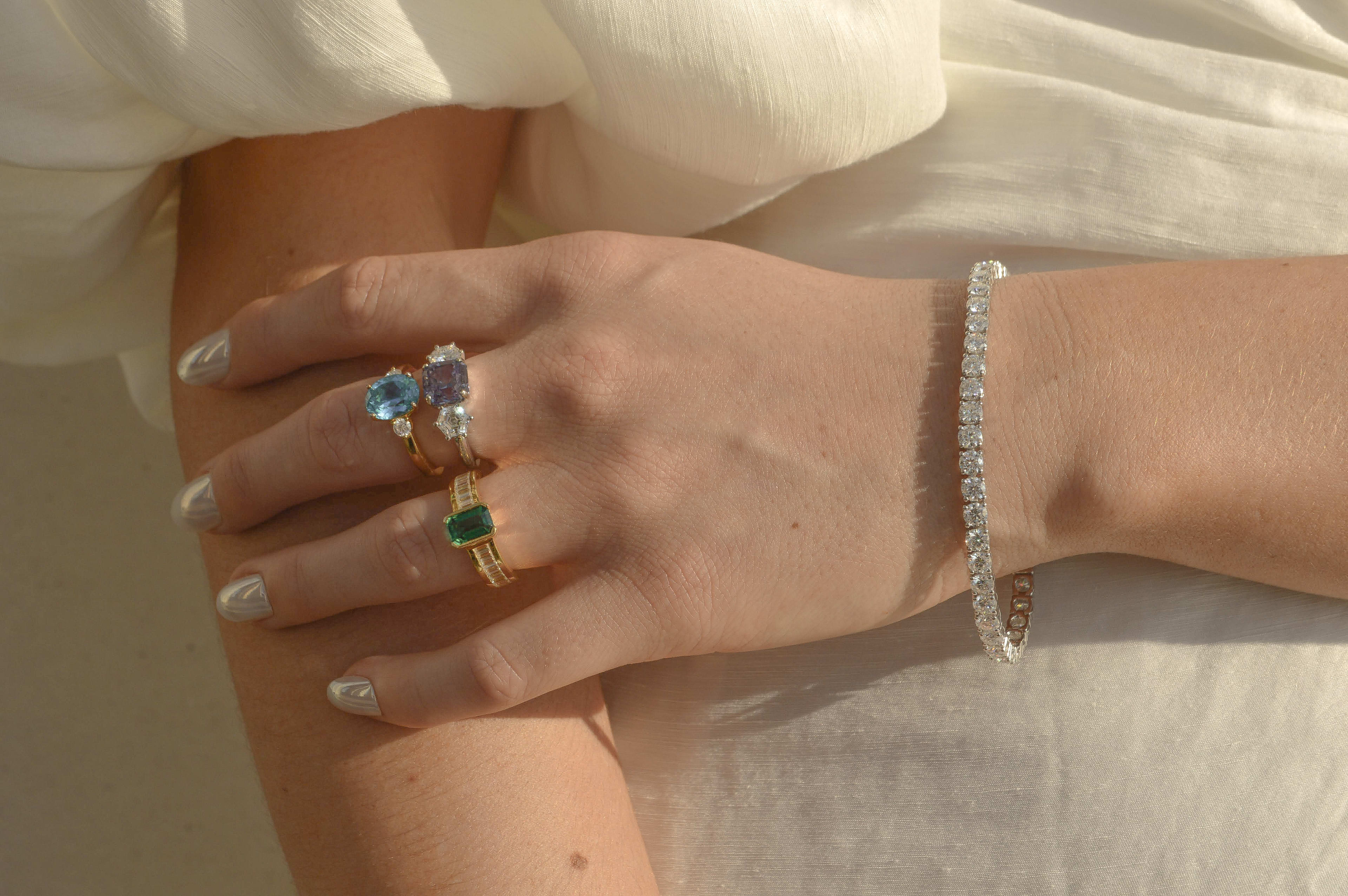 Different coloured sapphire rings featuring diamonds. 