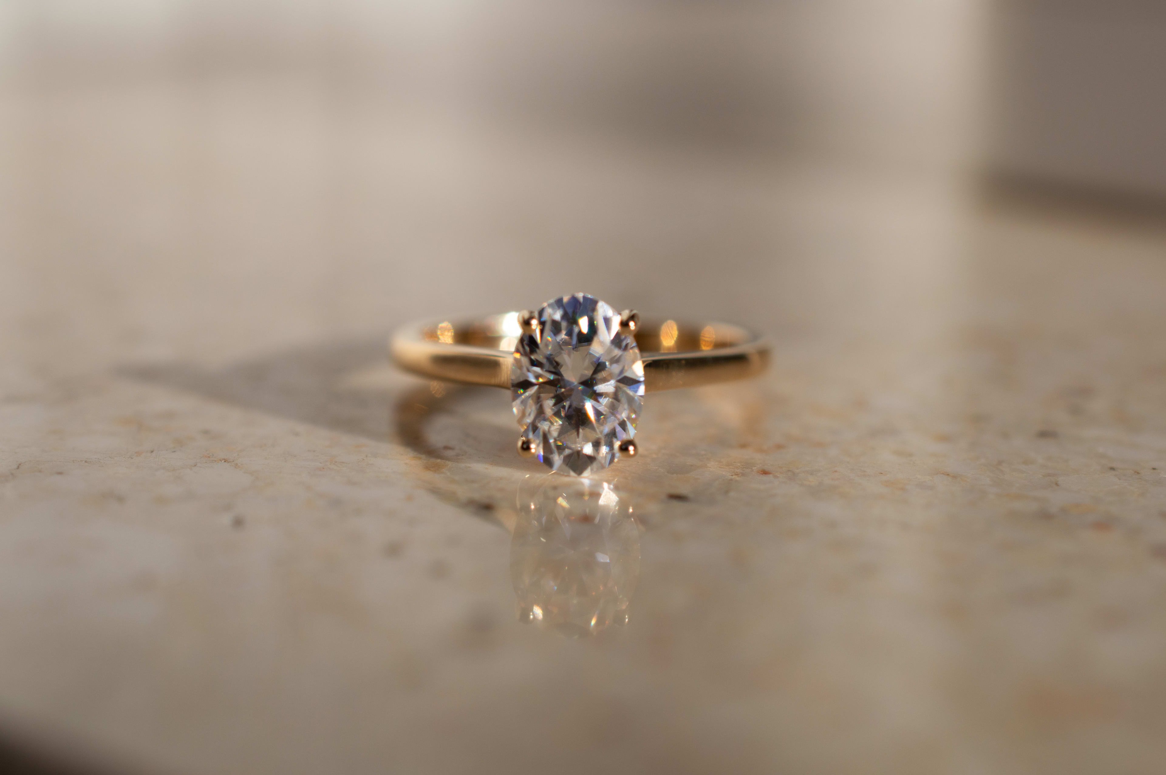 Oval solitaire engagement ring in a yellow gold band