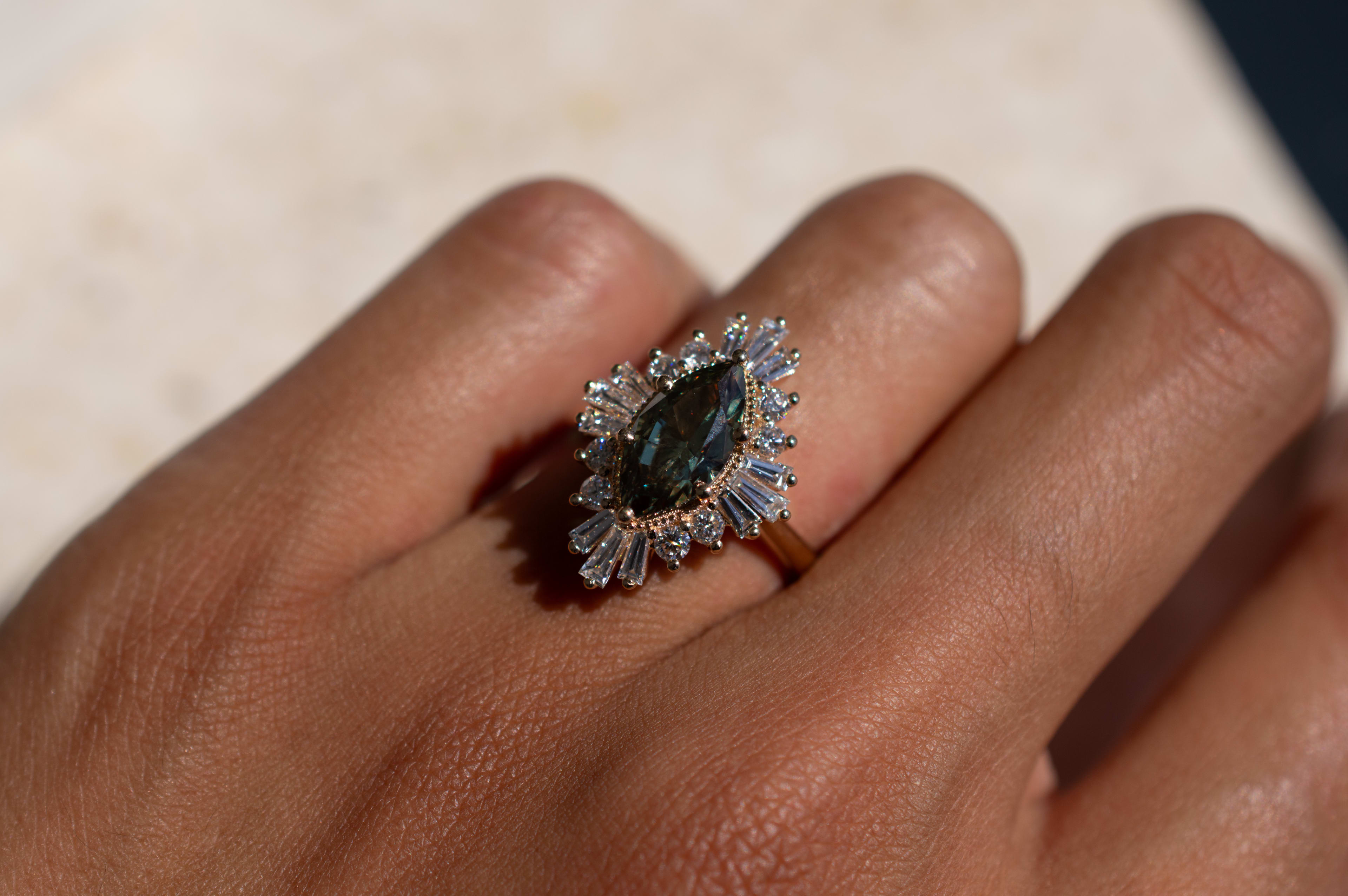 1.5 carat equivalent marquise cut green sapphire featuring a styled halo in a yellow gold band