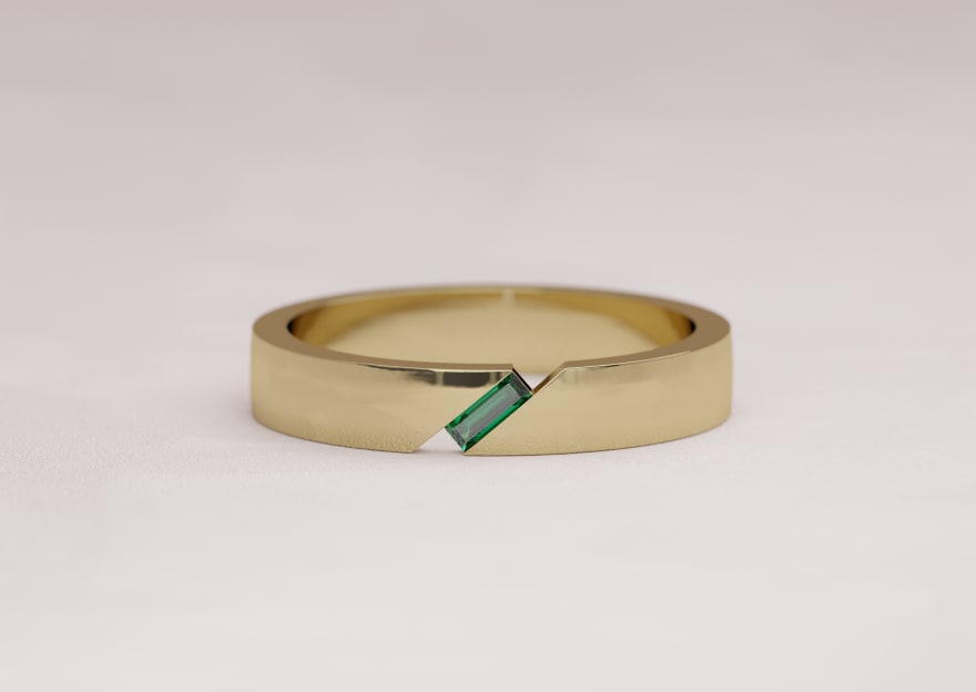 Mens wedding band featuring a portrait cut asymmetric emerald in 18k yellow gold