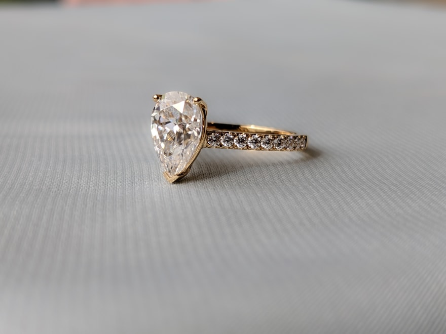 Solitaire Pear Cut in Gold with Melee Diamonds