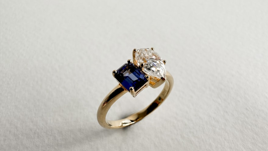 Toi et moi featuring a 1.5 carat pear cut diamond with an emerald cut sapphire in a 14K yellow gold band