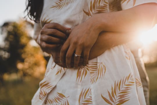 Couple embracing with Four Word engagement ring