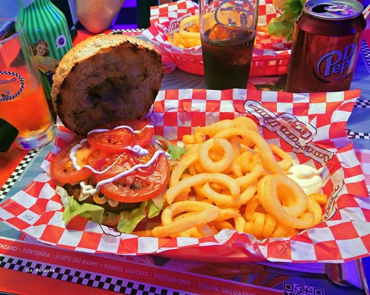 The 1950s American Diner has a very cute interior with its bright orange design, vintage booths, and a 1950s-style American interior