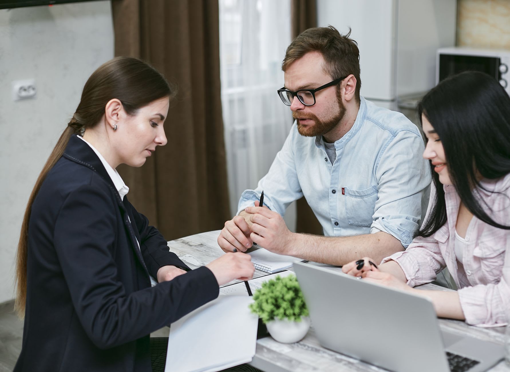 Couple meeting a mortgage advisor reviewing financing documents