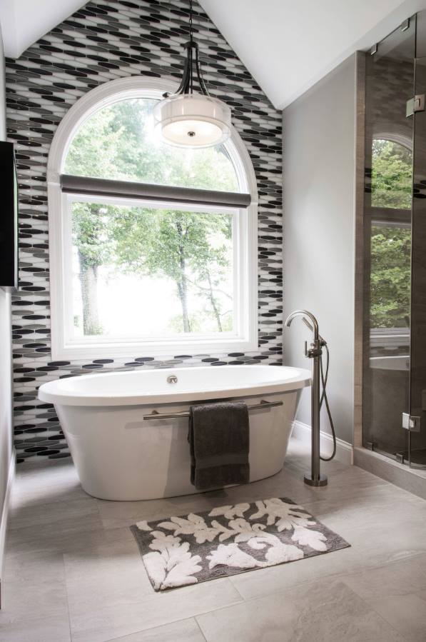 The accent wall enhances the tub as an focal point and visually divides the open bathroom floor-plan as part in a Bathroom Decor for 2020