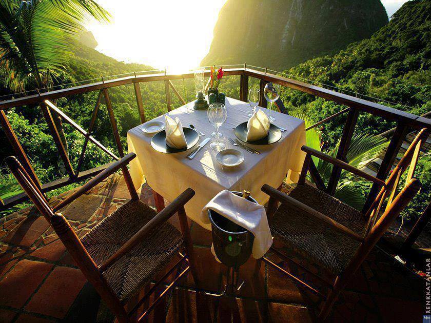 Dinner table & wicker chairs with view on the rain forest from the balcony