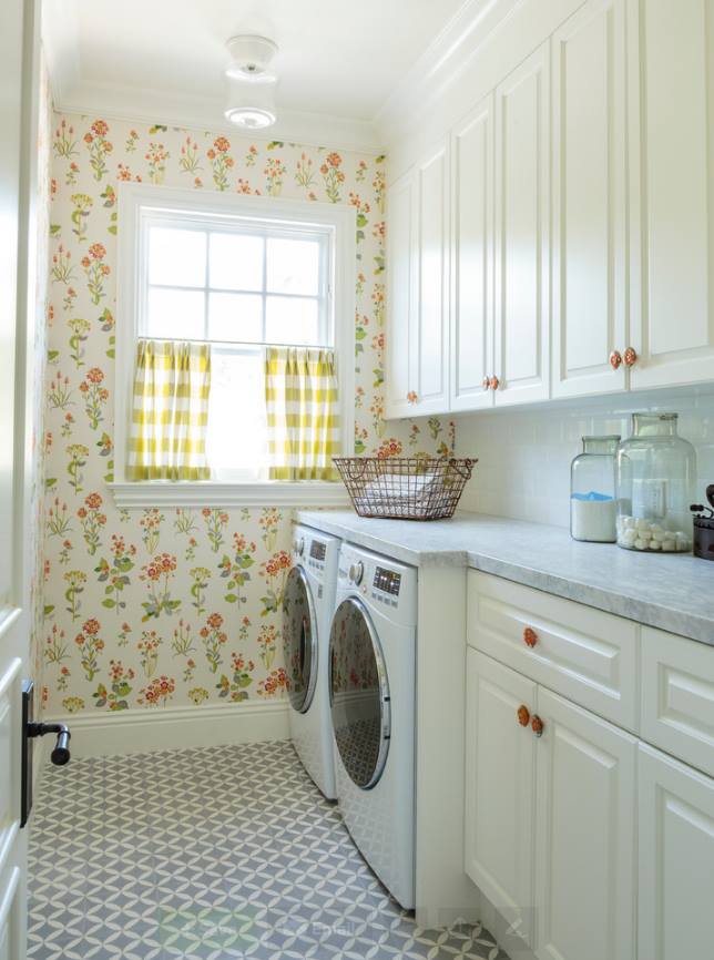 The floral design wallpaper brings this beautiful laundry room to life, With its cream color cabinetry And the white marble countertop is would fit mostly into any home design. And the window literally invited the sunlight in