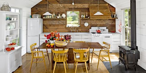 This rustic white kitchen loads autumnal appeal thanks to a bounty of recently chosen fall gifts (apples, flowers, and squash) onto the screen