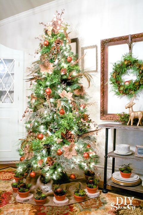 The DIY Showoff
shared their christmas tree decorations in grapevine orbs and burlap poinsettias, what seams like a try for cat defense are the super cute potted succulents that circle the tree skirt.
Tutorial @ The DIY Showoff.