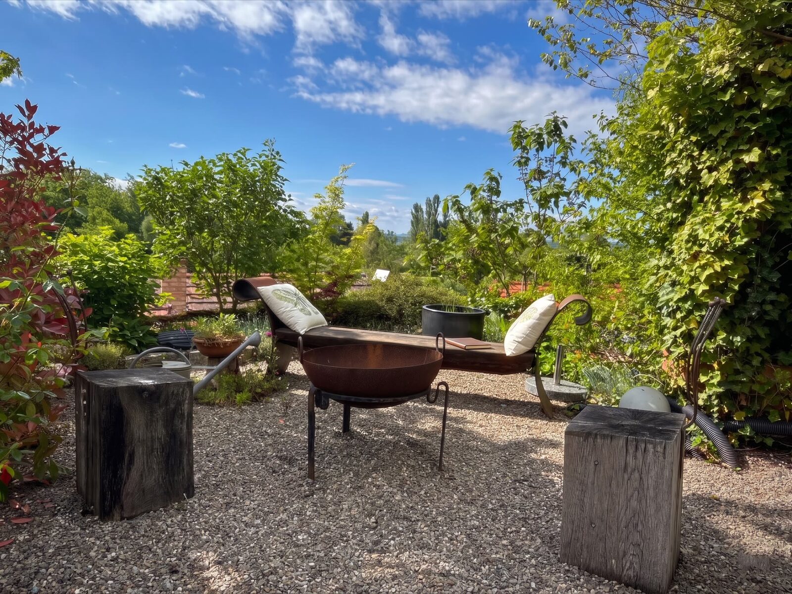 Feuerschale mit Liegestühlen und Gartenblick