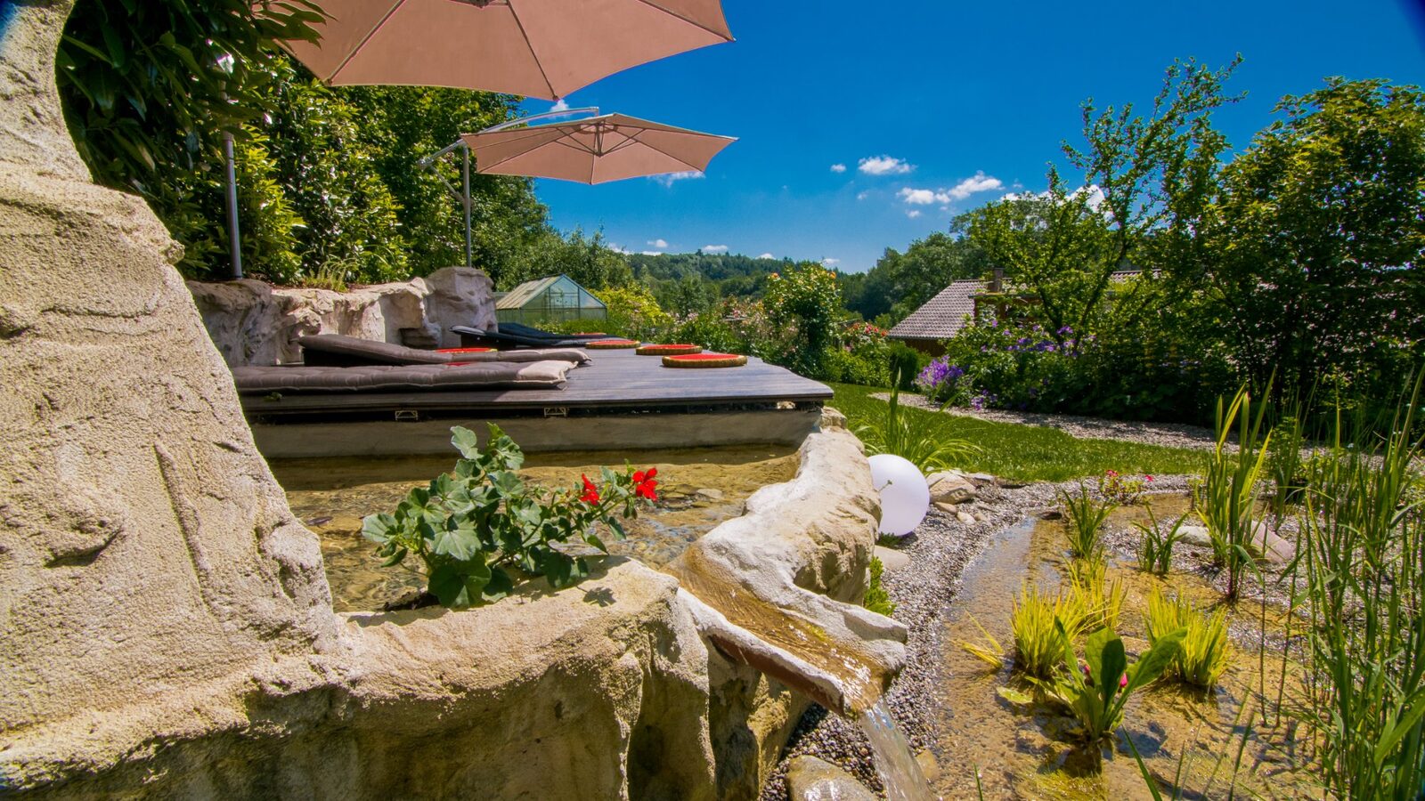 Sonnendeck mit Sonnenschirm und Wassergrotte