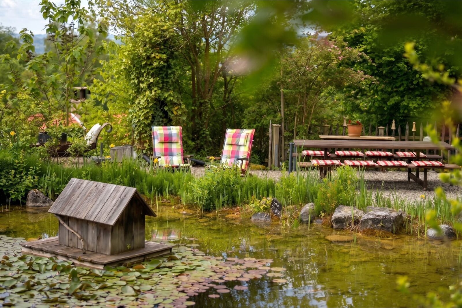 Sitzplatz mit Liegestühlen am Gartenteich