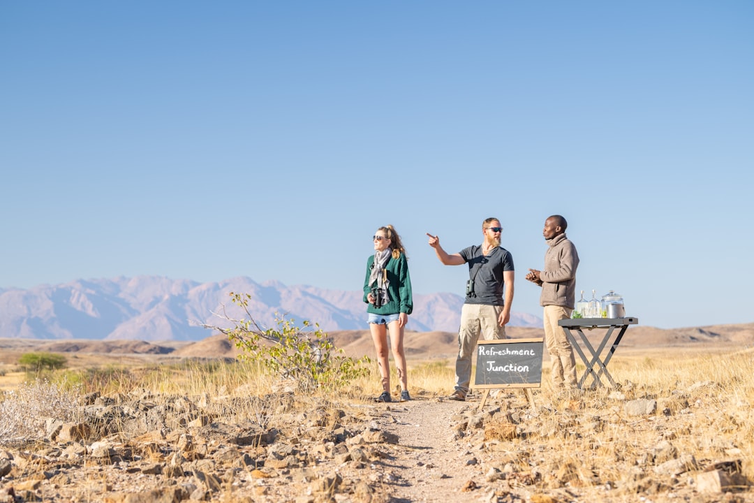 a group of people standing on top of a dirt field