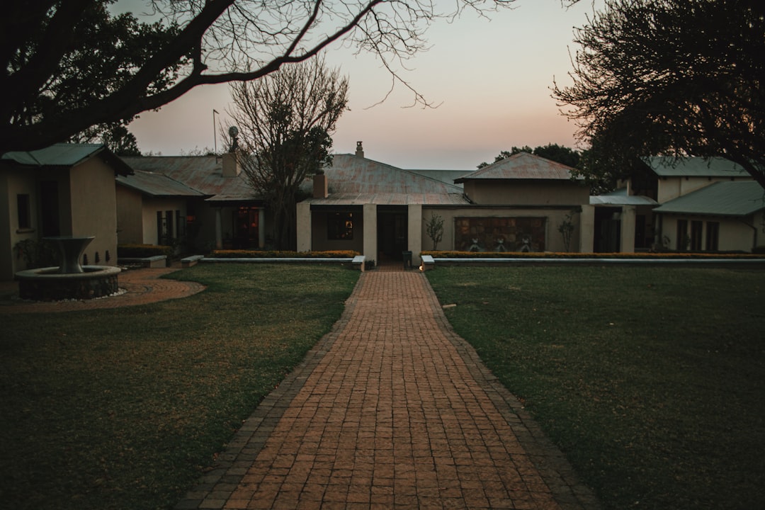 a brick path leading to a house in the evening