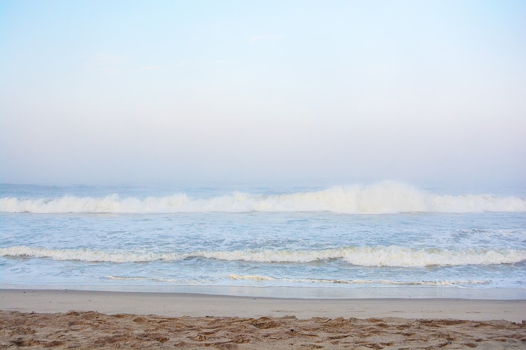 a person walking on the beach with a surfboard