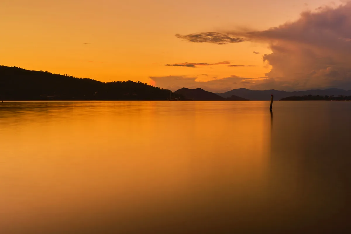 Prado reservoir Tolima Colombia lake calm water mountains sunset