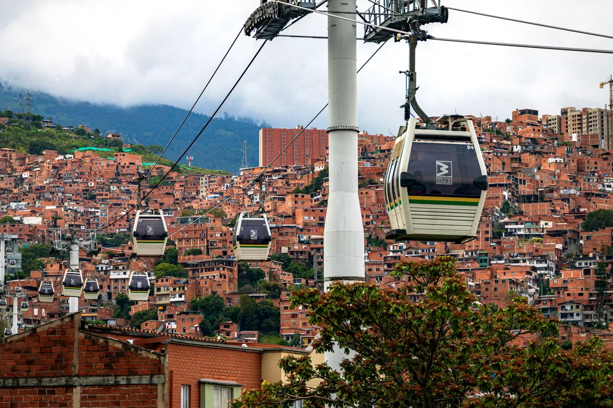 Medellin Colombia Metrocable cable car rising over hillside comunas aerial view