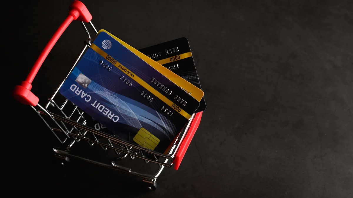 Tarjetas de crédito dentro de un carrito de supermercado en miniatura