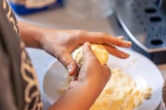 Manos que amasan una bola de masa sobre un plato