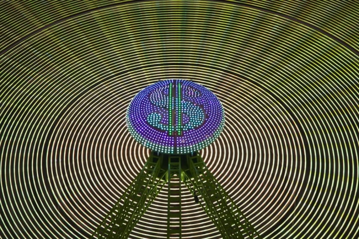 Signo de dólar luminoso en el centro de una estructura circular de luces verdes