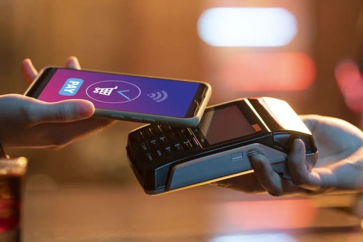 Pago con el celular acercado a una terminal punto de venta