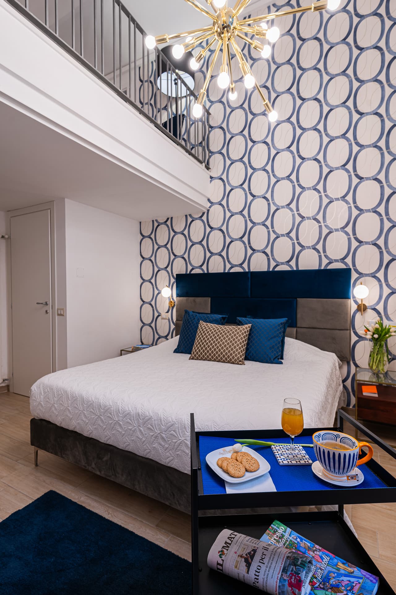 Suite Bella 'Mbriana di Daymoon House Vanvitelli a doppia altezza, con soppalco, lampadario sputnik e colazione servita sul letto