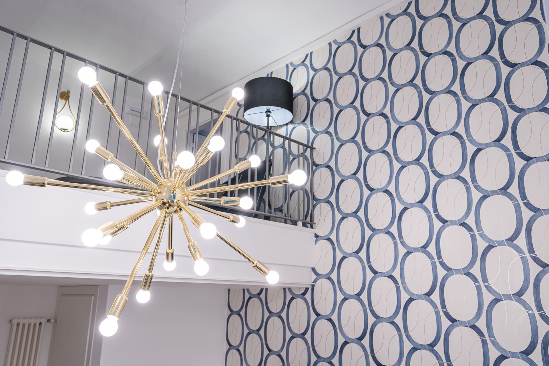 Lampadario sputnik dorato della suite Bella 'Mbriana e ringhiera del soppalco