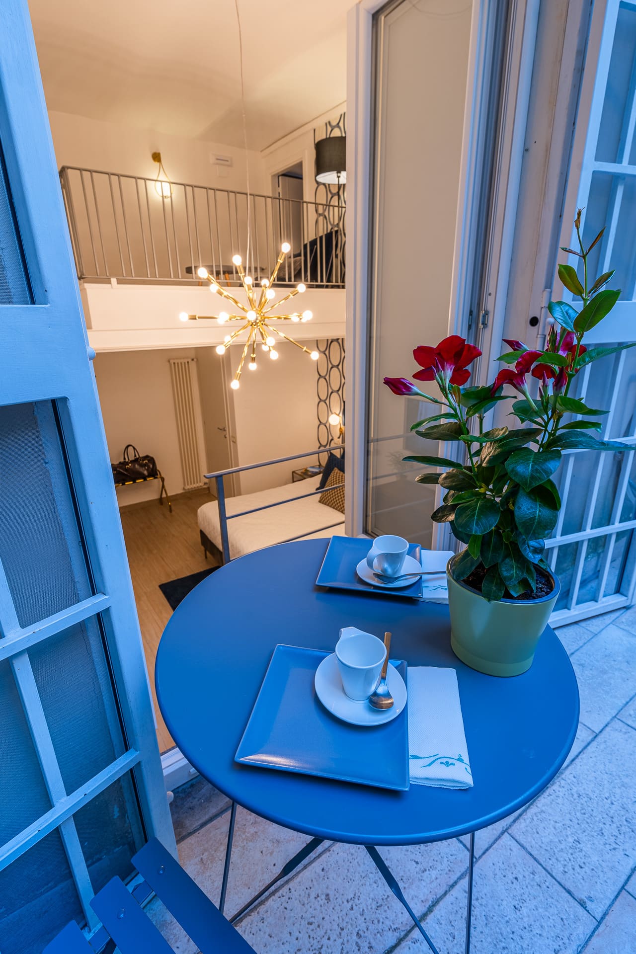 Terrazzo privato della suite Bella 'Mbriana apparecchiato per la colazione la sera, con vista sul soppalco illuminato