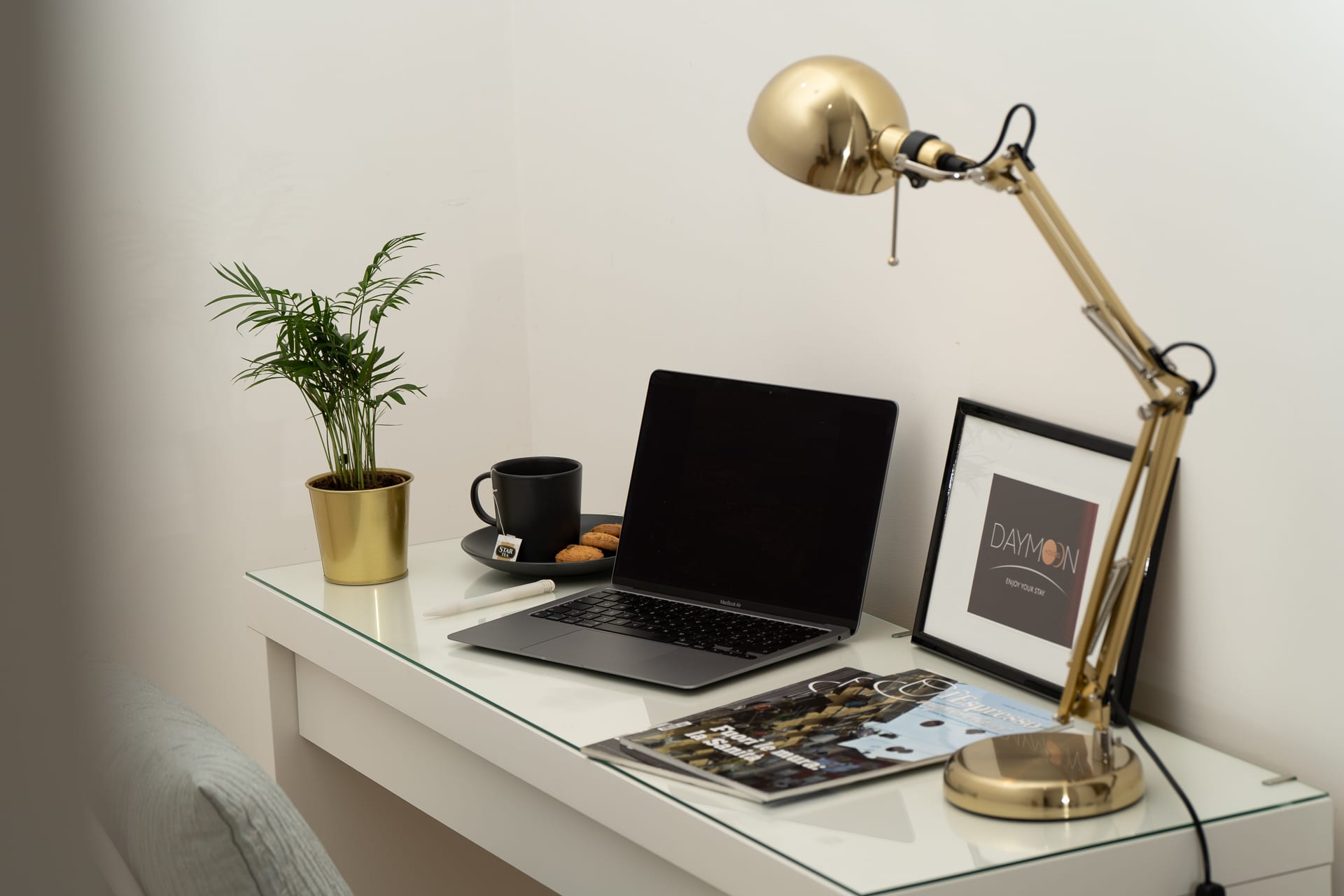 Angolo smart working di Daymoon House Merliani, con scrivania, lampada da tavolo dorata e laptop