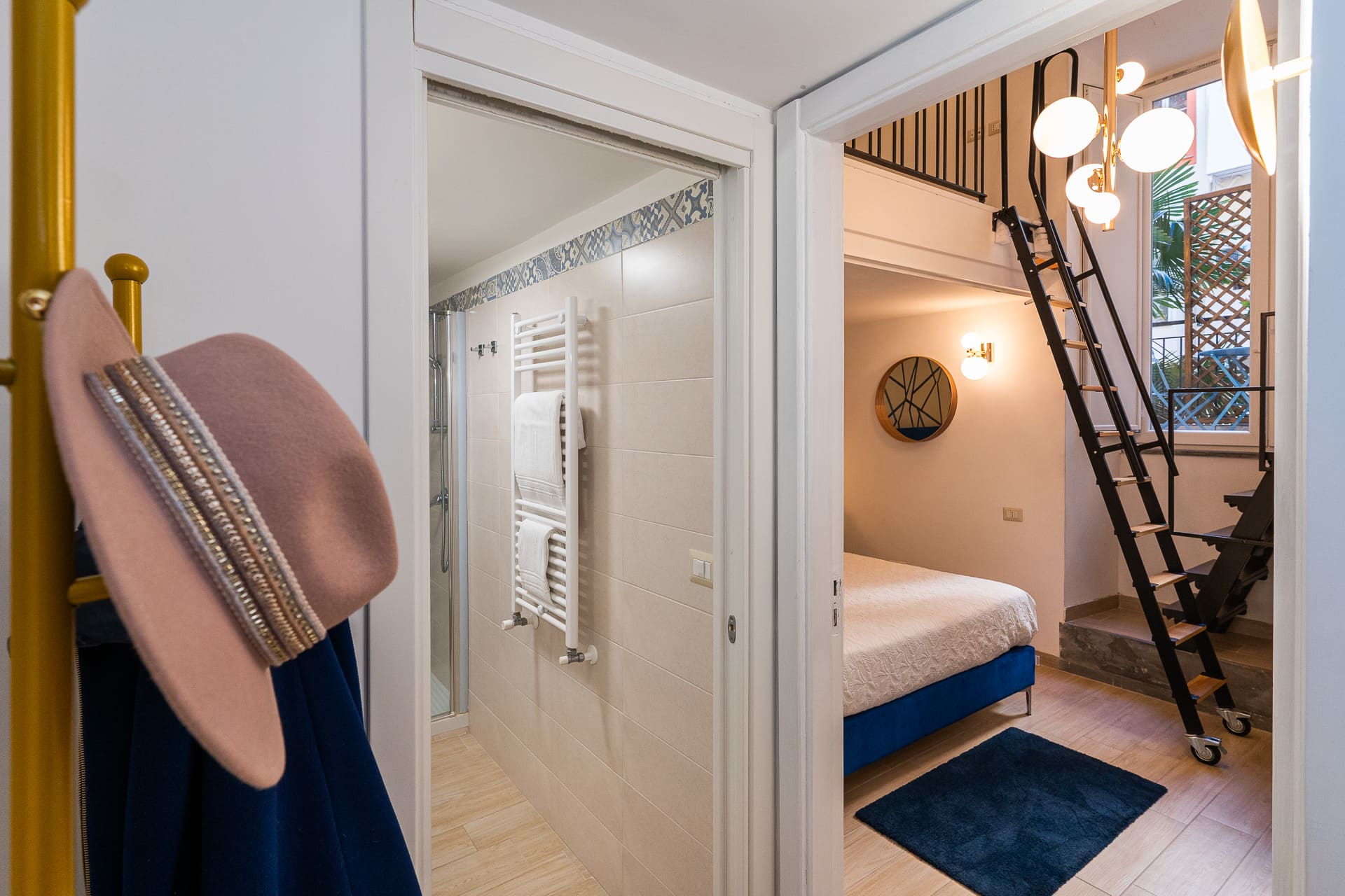 Ingresso della camera Megaride con appendiabiti in ottone e scorci del bagno privato e della zona letto
