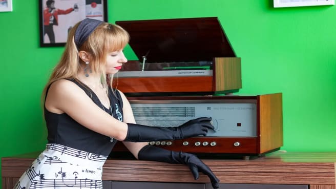 A woman tuning the 70s radio for music.