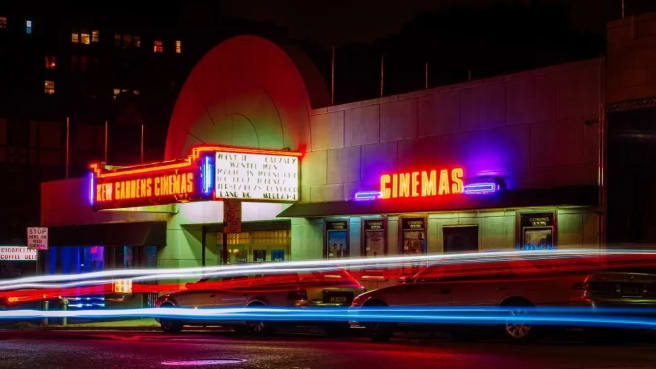 A cinema with colorful neon lights, presenting the best films.